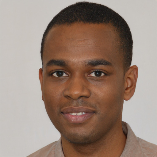 Joyful black young-adult male with short  black hair and brown eyes