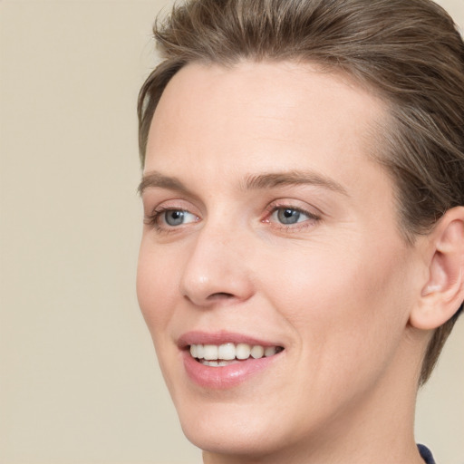 Joyful white young-adult female with short  brown hair and blue eyes