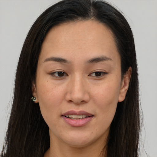 Joyful asian young-adult female with long  brown hair and brown eyes