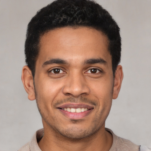 Joyful latino young-adult male with short  black hair and brown eyes