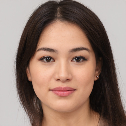 Joyful asian young-adult female with long  brown hair and brown eyes