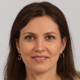 Joyful white adult female with long  brown hair and grey eyes