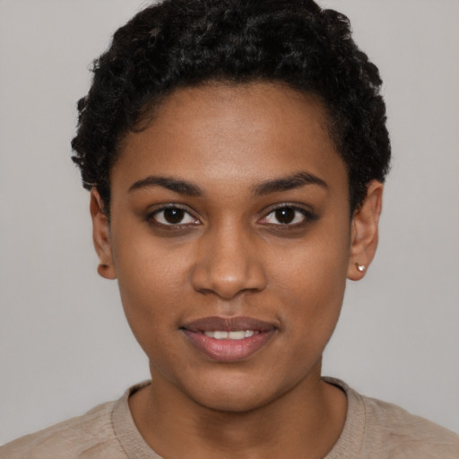 Joyful black young-adult female with short  black hair and brown eyes