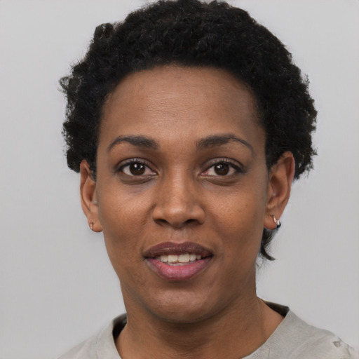 Joyful black adult female with short  black hair and brown eyes