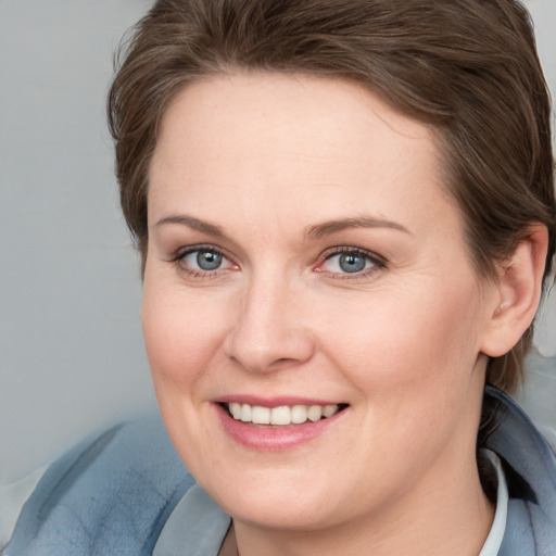 Joyful white young-adult female with medium  brown hair and blue eyes