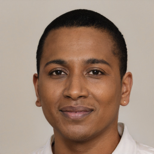 Joyful black young-adult male with short  black hair and brown eyes