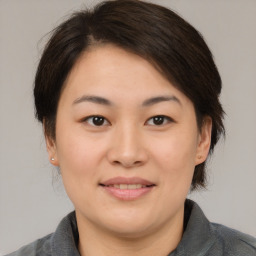 Joyful asian young-adult female with medium  brown hair and brown eyes