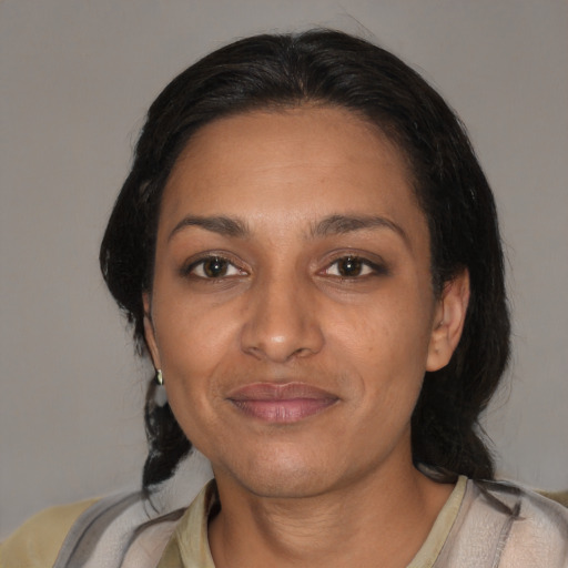 Joyful latino adult female with medium  black hair and brown eyes