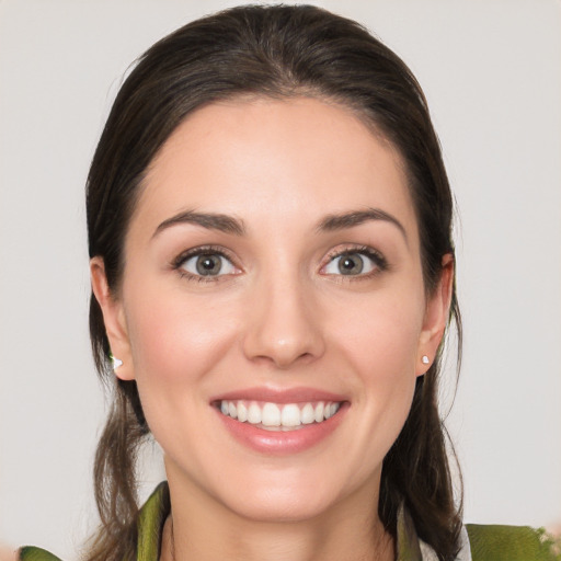 Joyful white young-adult female with medium  brown hair and green eyes