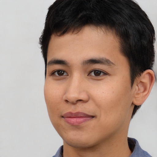 Joyful asian young-adult male with short  brown hair and brown eyes