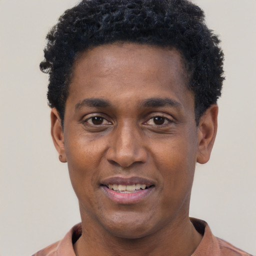 Joyful black young-adult male with short  black hair and brown eyes