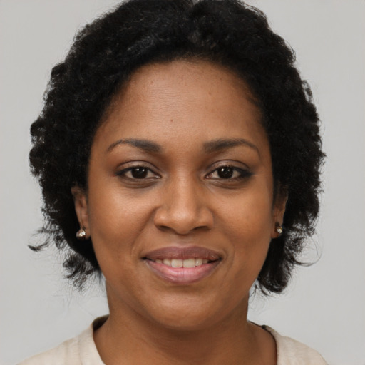 Joyful black adult female with short  black hair and brown eyes