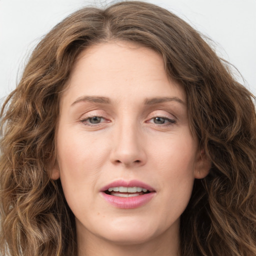 Joyful white young-adult female with long  brown hair and green eyes