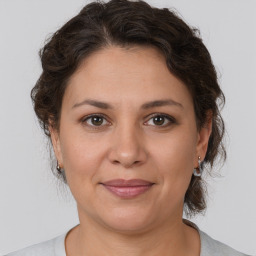 Joyful white adult female with medium  brown hair and brown eyes