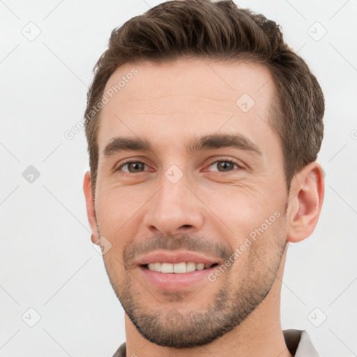 Joyful white young-adult male with short  brown hair and brown eyes