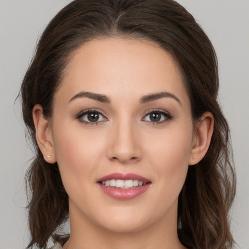 Joyful white young-adult female with long  brown hair and brown eyes