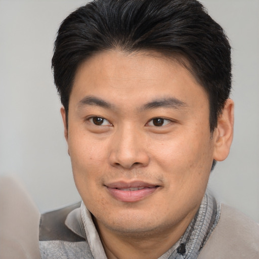 Joyful asian young-adult male with short  brown hair and brown eyes