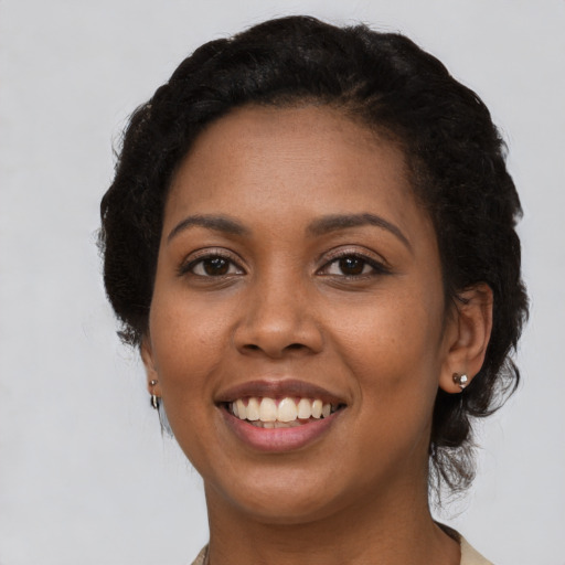 Joyful black young-adult female with short  black hair and brown eyes