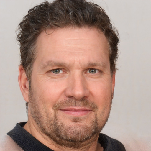 Joyful white adult male with short  brown hair and blue eyes