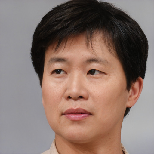 Joyful asian adult male with short  brown hair and brown eyes