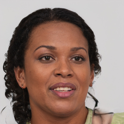 Joyful black adult female with medium  brown hair and brown eyes