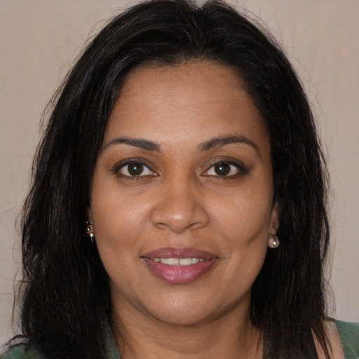 Joyful black young-adult female with long  brown hair and brown eyes