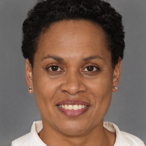 Joyful black adult female with short  brown hair and brown eyes