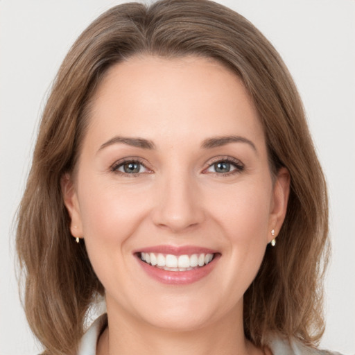 Joyful white young-adult female with medium  brown hair and grey eyes