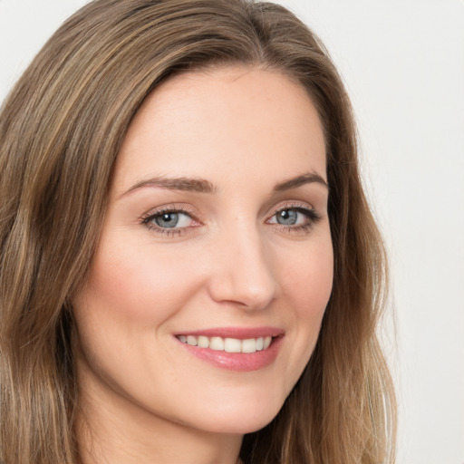 Joyful white young-adult female with long  brown hair and green eyes