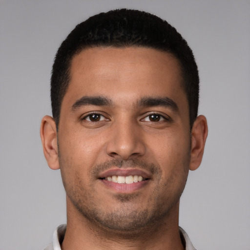 Joyful latino young-adult male with short  brown hair and brown eyes