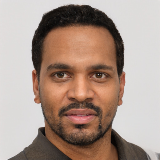 Joyful black young-adult male with short  black hair and brown eyes