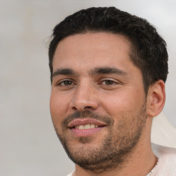 Joyful white young-adult male with short  black hair and brown eyes