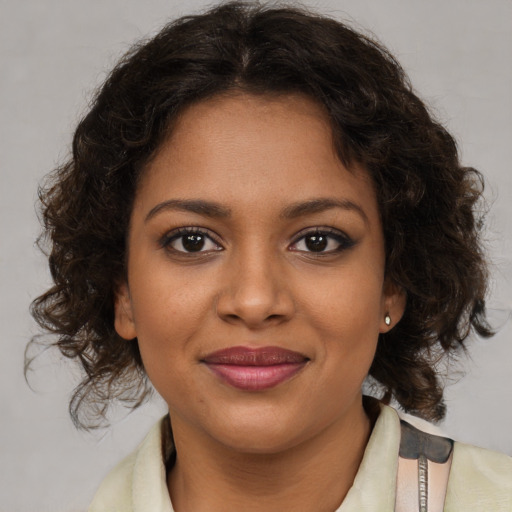 Joyful black young-adult female with medium  brown hair and brown eyes