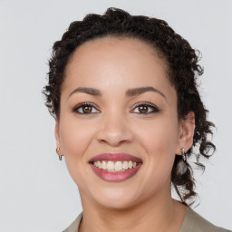 Joyful black young-adult female with long  brown hair and brown eyes