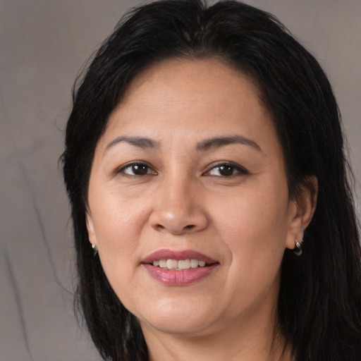 Joyful latino adult female with long  brown hair and brown eyes