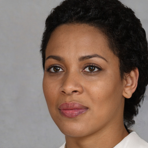 Joyful black young-adult female with short  black hair and brown eyes