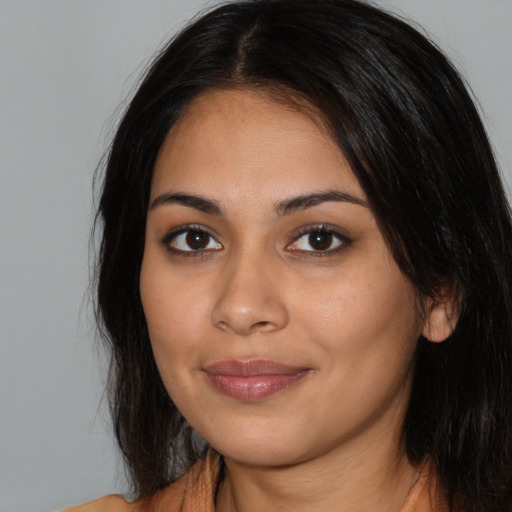 Joyful latino young-adult female with long  black hair and brown eyes