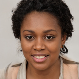 Joyful black young-adult female with long  brown hair and brown eyes