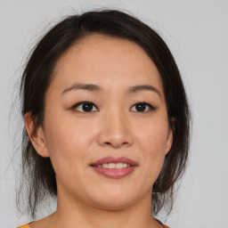 Joyful asian young-adult female with medium  brown hair and brown eyes