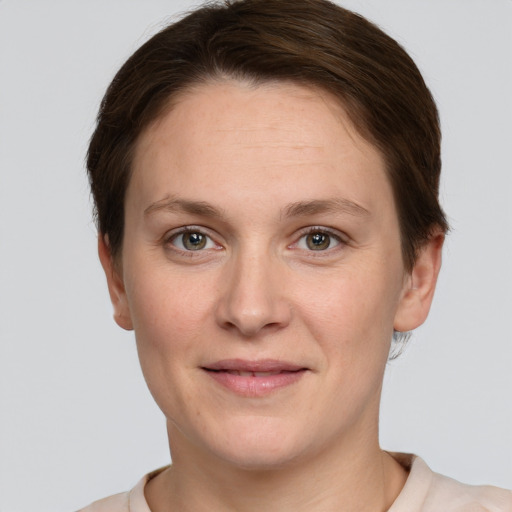 Joyful white young-adult female with short  brown hair and grey eyes