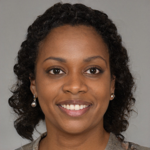 Joyful black young-adult female with medium  brown hair and brown eyes