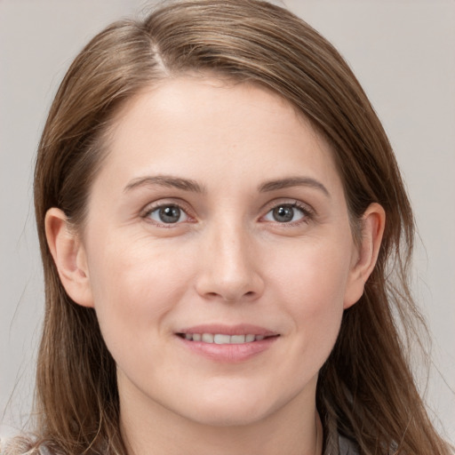 Joyful white young-adult female with long  brown hair and grey eyes