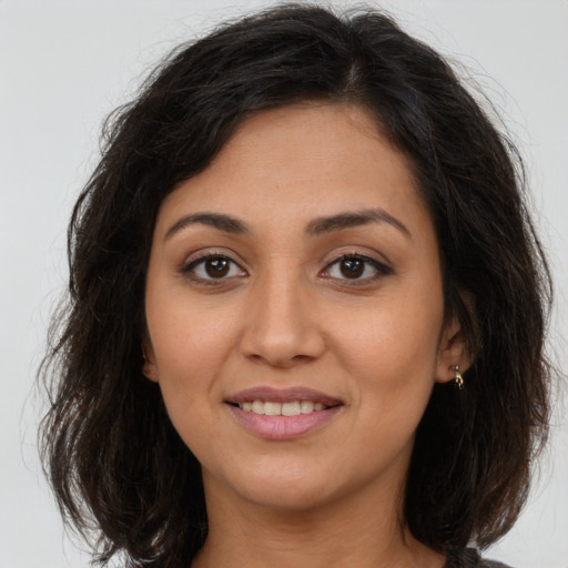 Joyful latino young-adult female with long  brown hair and brown eyes