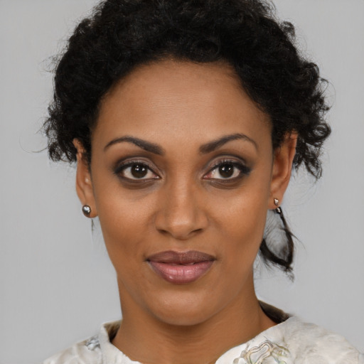 Joyful black young-adult female with medium  brown hair and brown eyes