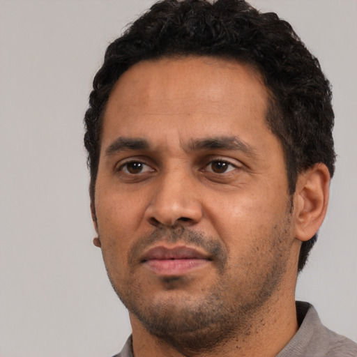 Neutral latino adult male with short  black hair and brown eyes