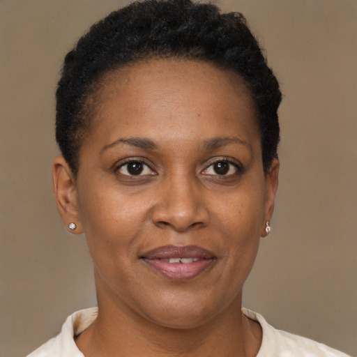 Joyful black adult female with short  brown hair and brown eyes
