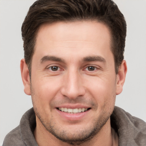 Joyful white young-adult male with short  brown hair and brown eyes