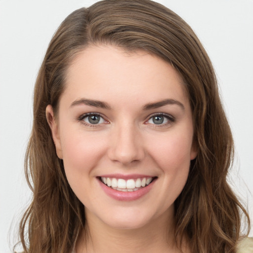 Joyful white young-adult female with long  brown hair and green eyes