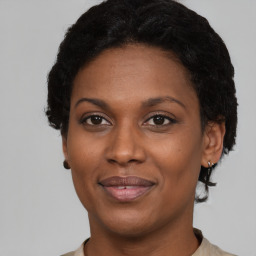 Joyful black adult female with short  brown hair and brown eyes