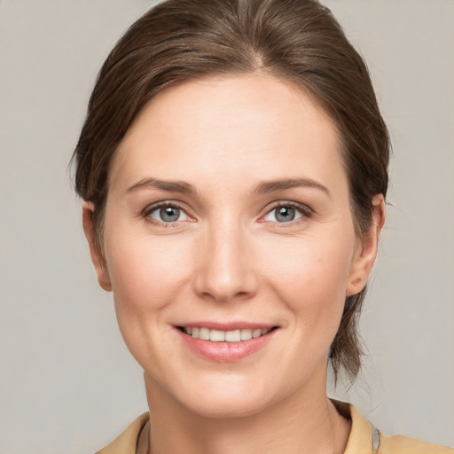 Joyful white young-adult female with medium  brown hair and grey eyes